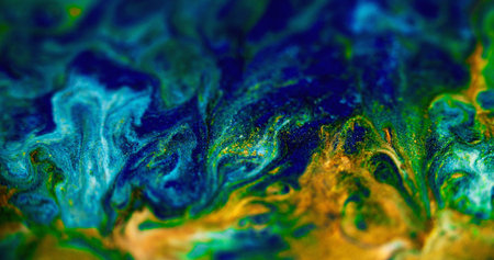 Sparkling ink blend. Wet glitter flow. Defocused golden cyan blue color metallic shimmering particles marble texture paint splash abstract art background.の写真素材