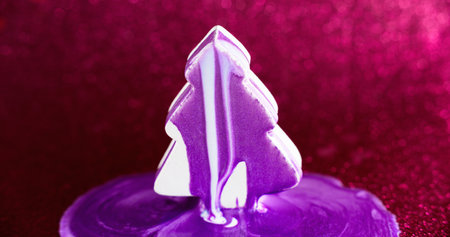 Paint fir tree. Xmas decoration. Purple white color shimmering ink drip spill over abstract conifer shape on defocused pink bokeh light background.の写真素材