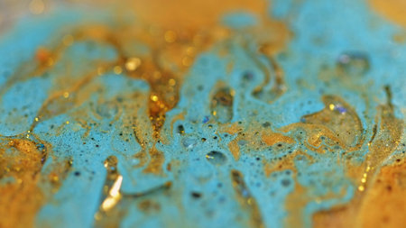 Liquid glitter spill. Sparkling ink. Blur blue golden color metallic sequin particles gloss bubbles...