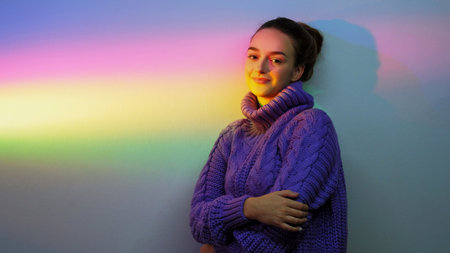 Rainbow portrait. Positive mind. Peaceful energy. Inspired relaxed girl on defocused neon gradient color light copy space background.の写真素材