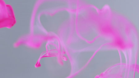 Color water. Gleaming splashes. Pink graphic bright gradient falling flow on modern white art abstract background. Sparkling liquid fluid.の写真素材