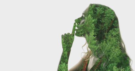 Artwork face. Nature tranquility. Double exposure profile woman silhouette with green moving trees in hair showing shhh with finger at lips isolated on white copy space background.の写真素材