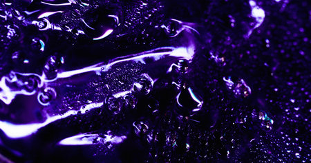 Raindrop surface. Color condensation. Illuminated defocused violet area covered with flowing water drops foil effect. Smooth humidity background texture.の写真素材