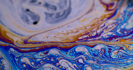 Blur psychedelic fluid. Paint flow. Defocused multicolor purple green liquid rainbow curve acrylic slick on dark black light abstract light art background.の写真素材