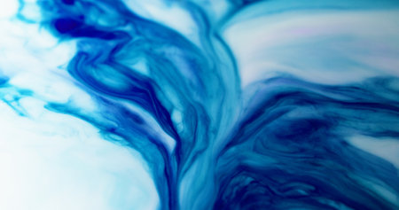 Ink splash. Wavy paint. Dissolution contrasting expansion blue dye on light defocused opaque enamel. Intricate color ripples blend on acrylic surface.の写真素材