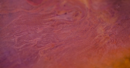 Liquid marble. Blurred sparkling paint. Defocused purple yellow color shiny glitter particles ink...