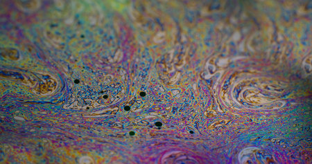 Rainbow curve. Acrylic slick. Defocused multicolor purple green liquid oil paint curve acrylic on dark black blurred light abstract art background.の写真素材
