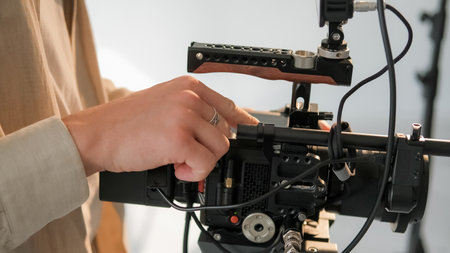 Cameraman hand. Video studio. Unrecognizable male operator adjust professional filming equipment....