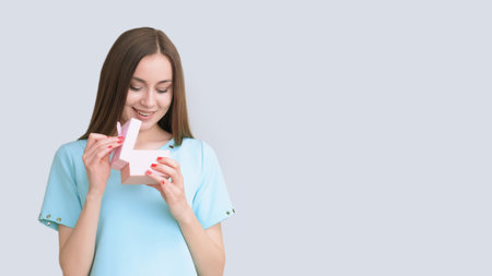 Wonder girl. Unexpected surprise. Amazed happy woman in blue guessing present in small box isolated on light copy space background.の写真素材