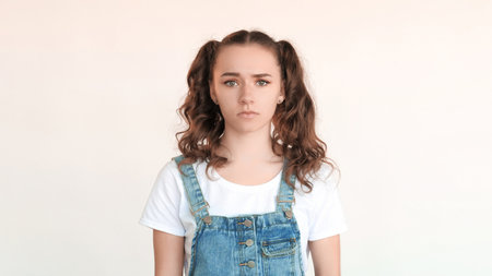 Upset female portrait. Failure regret. Hopeless shrug gesture negative emotion. Disappointed upset girl teenager feels sorry about mistake isolated on white copy space background.の写真素材