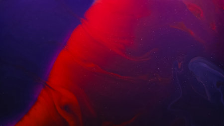 Ink wave. Fluid spill. Defocused purple red color paint chemical marble emulsion in water spreading...