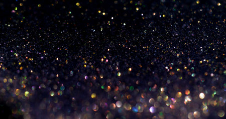 Sparkling shimmer. Shiny flare. Defocused golden blue purple color glitter celebration effect on dark black festive art background.の写真素材