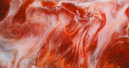 Pigment blend. Chemical glitter. Orange copper white paint spread shimmering liquid texture. Smooth mix particles blur abstract background.の写真素材