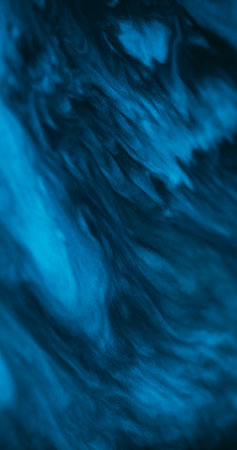 Fluid pigment. Stains art. Defocused blue color chemical water sparkling paint in liquid wave moving on abstract dark black background.の写真素材