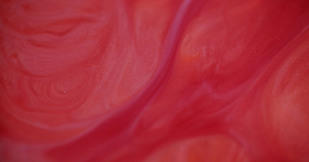 Wet ink texture. Defocused liquid spill. Bright beautiful gleaming smooth bright red flows motion on blurred bokeh light modern abstract background.の写真素材