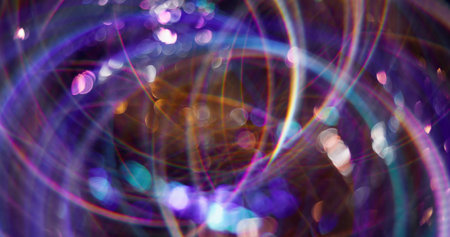 Neon circles. Defocused shiny sparkler. Purple color gleaming particles lens flare motion on abstract bokeh light blurred modern background.の写真素材