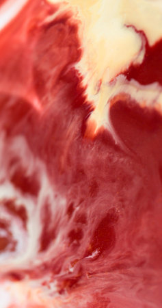Splash art. Shiny stains. Defocused red yellow colorful marble enamel texture paint flow in water...