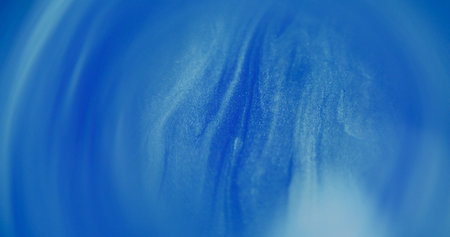 Blur glitter fluid. Water shimmer. Sparkling white blue color blinking liquid paint ink bright dust moving on abstract bokeh light background.の写真素材