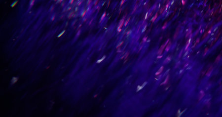 Light flare. Defocused rainbow reflection. Purple color blinking sparkling lens liquid motion on blurred bokeh abstract modern background.の写真素材