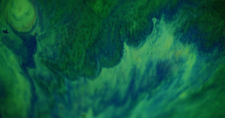 Shimmer paint. Defocused natural spray. Beautiful green sparkling colorful liquid turning on blurred wave bokeh light abstract background.の写真素材