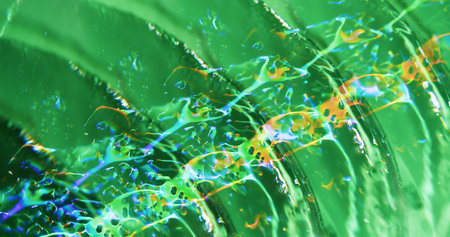 Defocused colorful sparkling. Glow texture. Green lens flare swirling on blurred abstract blue light...
