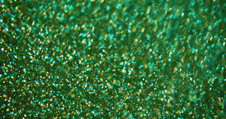 Glittering flare. Defocused celebrate sparks. Multicolor green gleaming bright particles motion on blurred bokeh light modern background.の写真素材