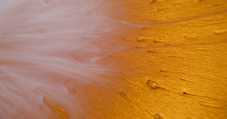 Glitter blob. Paint burst. Shiny golden precious sparkling liquid explosion spill particles. Art metal powder blotch abstract blur background.の写真素材
