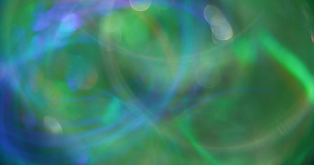 Blurred lens flare. Defocused glow. Multicolored blue green sparking circles gleaming bokeh light art abstract modern background.の写真素材