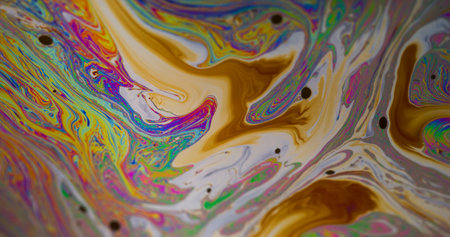 Oil drop. Ink blend. Defocused green yellow blue color pink purple round texture floating on abstract dark black creative background.の写真素材