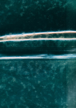 Damaged foil texture. Aged film overlay. Green orange white color stain light flare scratch dust defect creased uneven used surface art abstract background.の写真素材