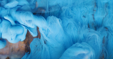 Smog blend. Color water. Defocused vibrant blue ink vapor swirling pigment particles spreading on acrylic art abstraction.の写真素材