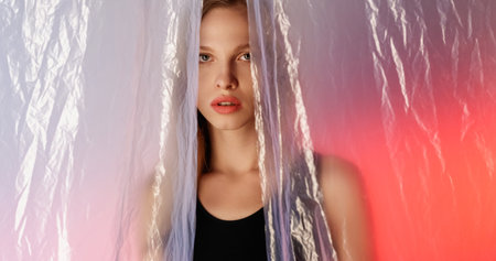 Skincare beauty. Concerned woman. Disturbed insecure girl hiding behind wrinkled polyethylene film...