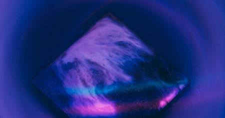 Cube ink splash. Neon texture. Defocused purple blue yellow colorful geometric rainbow sparkling liquid floating on abstract art background.の写真素材