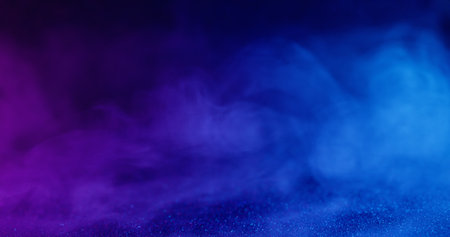 Atmospheric smoke. Sparkling vapor. Blur blue purple neon color paint in acrylic water sequins flying on abstract dark black background.の写真素材