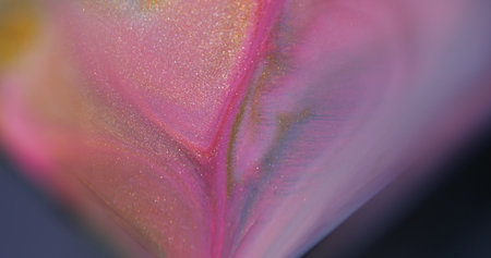 Sparkling paint. Fluid spill. Defocused purple pink yellow colorful splash liquid flowing texture drip on abstract bokeh background.の写真素材