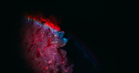 Glow paint. Neon fume art. Defocused purple blue pink colorful swirling rainbow texture floating on...