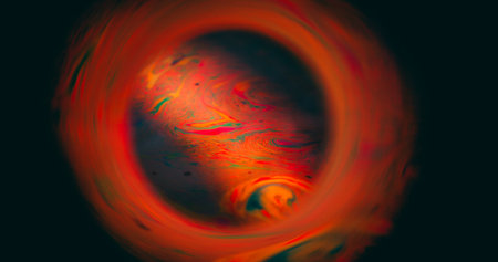 Spectrum defocused soap. Planet color eclipse. Cosmic sphere orange red ink blend on black background. Swirl glow leak abstract round frame.の写真素材