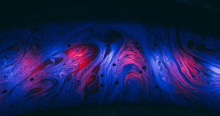 Soap colorful chaos. Defocused paint blend. Vibrant wave curl liquid. Red blue gradient fluorescent mix flare abstract black background.の写真素材