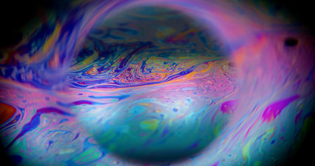 Defocused fluid. Mystical paint. Colorful light emulsion oil mix sphere. Blue purple cosmic background black space neon frame.の写真素材