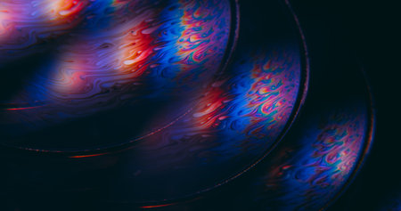 Fluorescent liquid blur. Psychedelic chemical ink. Colorful defocused round lens flow swirl blending dye abstract glow black background.の写真素材