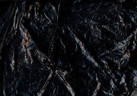Old sheet. Wrinkled black paper. Crumpled rough plastic grunge blank abstract background. Dark distressed flare blur aged texture.の写真素材