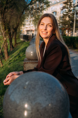 Outdoor portrait. Candid expression. Cheerful independent business woman enjoying sunlight in natural park.の写真素材