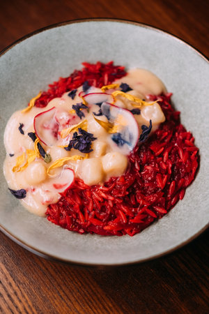 Gourmet dish. Shellfish recipe. Tasty spanish paella with scallop on plate. Seafood in creamy sauce on red tomato rice with seasoning.の写真素材