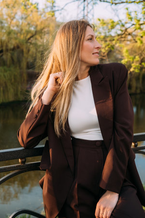 Nature contemplation. Outdoor portrait. Pensive smiling business woman enjoying fresh air in autumn park.の写真素材