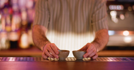 Sake cup. Serving alcoholic drink. Barkeeper putting on counter little empty clay bowls for...