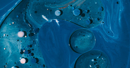 Oil flow. Bubble water. Defocused blue white purple color shiny paint round acrylic mix liquid...