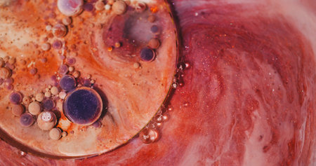 Paint bubbles. Oil background. Defocused purple orange color glitter acrylic blend liquid round flow...