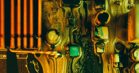 Paint spill. Electronic board. Defocused green orange yellow color glitter acrylic liquid microchip wet texture flow on abstract art background.の写真素材