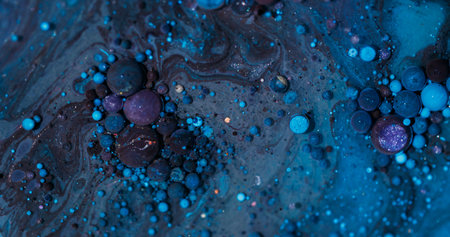 Oil stream. Bubble fluid. Defocused blue purple color round glitter paint acrylic wet texture floating on abstract vibrant background.の写真素材