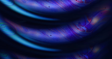 Defocused light liquid. Acrylic fuel. Blue purple color flow chemical bubble curve paint neon water floating on abstract art black background.の写真素材
